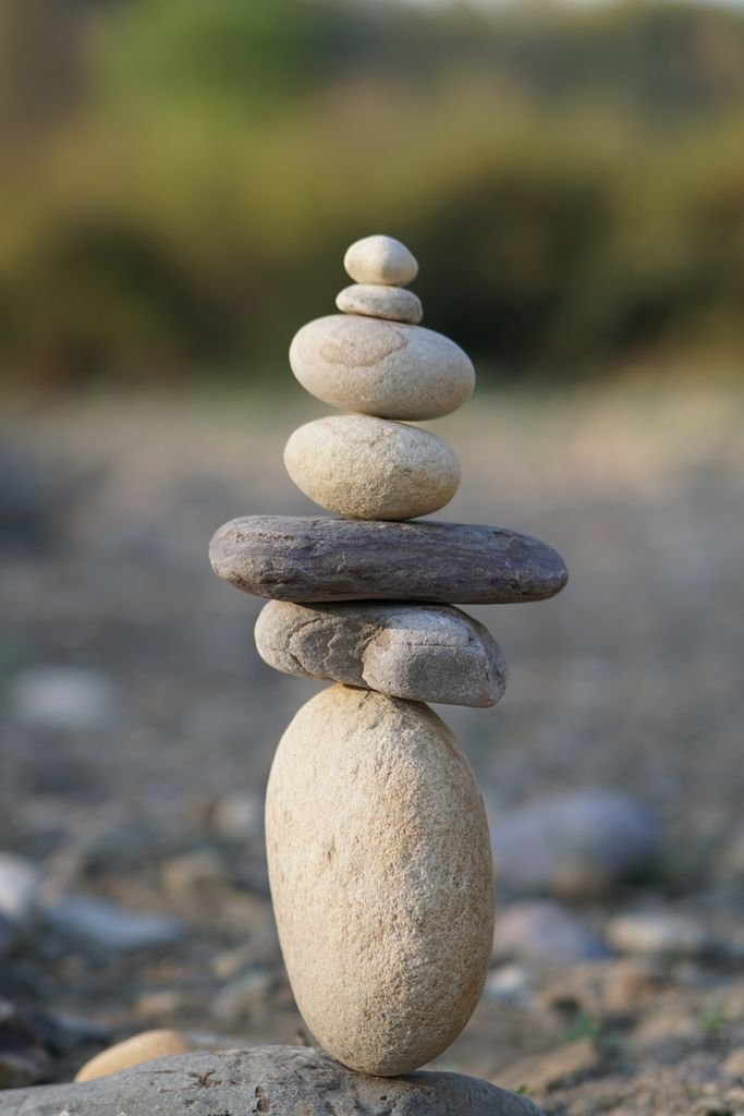 A serene stack of balanced stones outdoors, symbolizing harmony and balance.